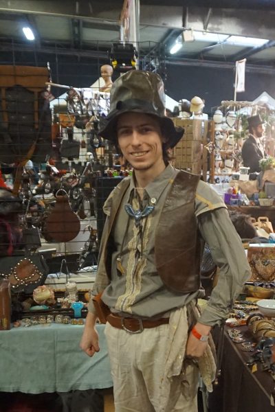 Personnage costumé devant un stand de bijoux et bibelots à Normannia 2019