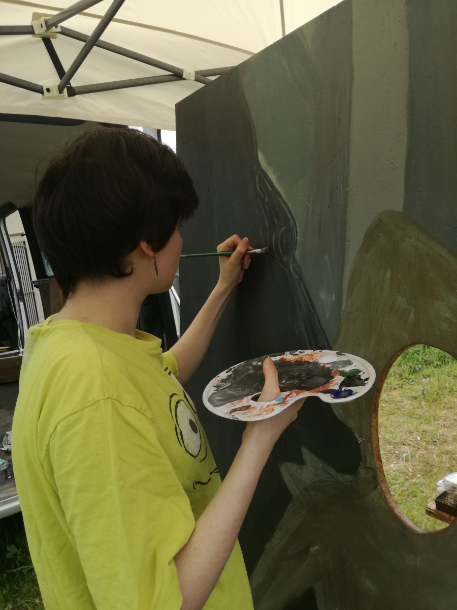 Membre de l'équipe du Projet CarTylion en train de peindre avec une palette à la main