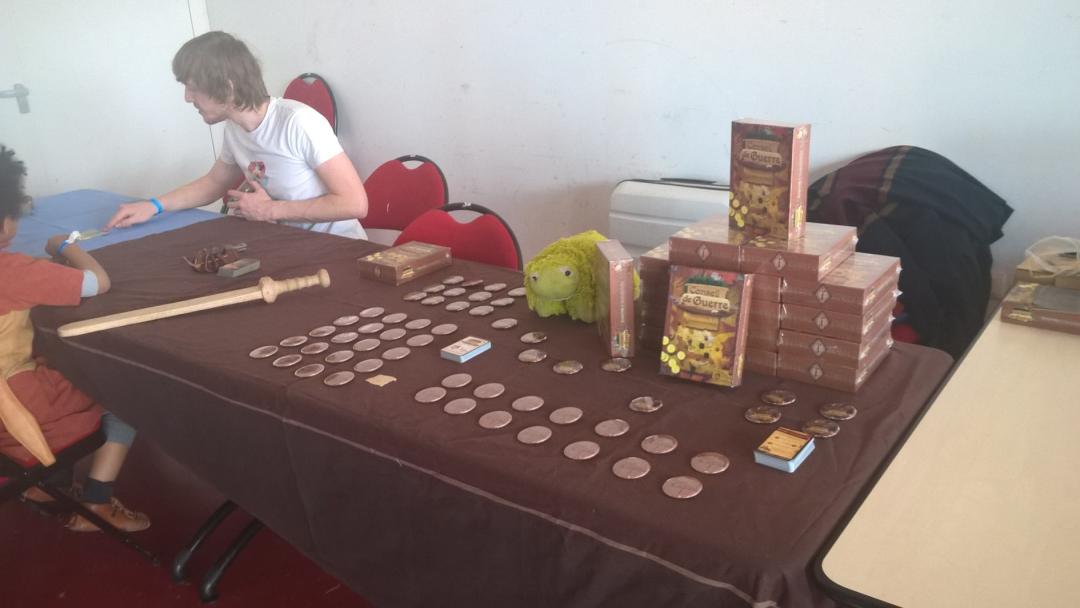 Table avec jeux Conseil de Guerre et badges Victore présentant le jeu