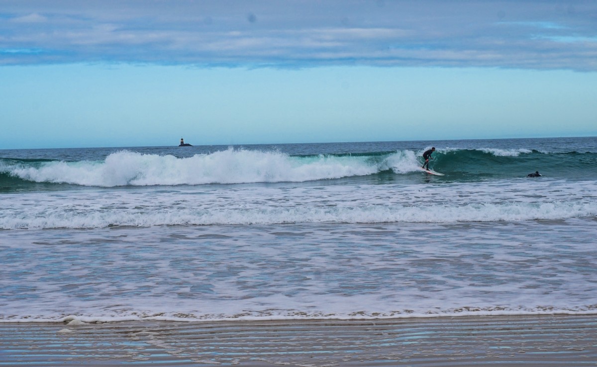 Un surfeur debout et un sur sa planche sur la mer