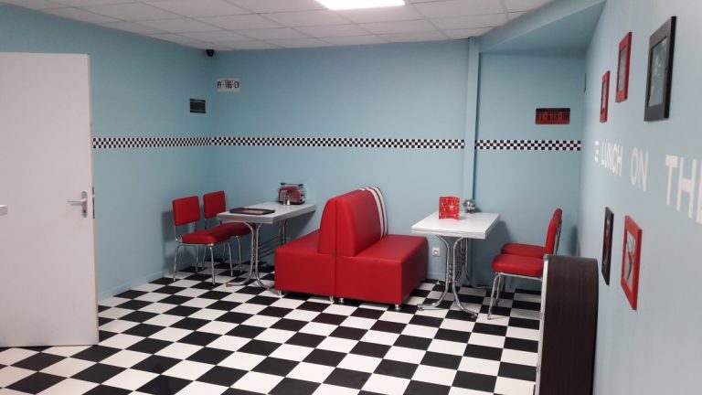 Diner américain style années 1950 avec banquettes rouges et damier au sol