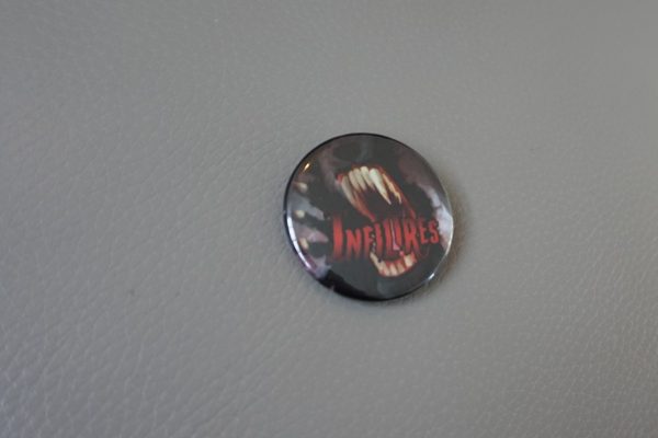 Badge épingle rond 38mm avec une gueule de loup-garou et le titre Infiltrés